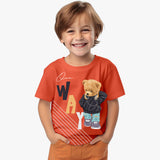 A smiling boy wearing an orange t-shirt with a teddy bear graphic and text on the front.