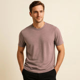 Man wearing a mauve t-shirt against a beige background
