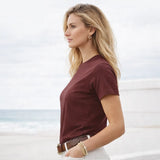 Woman wearing a maroon t-shirt on a beach