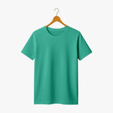 Green t-shirt on a wooden hanger against a white background
