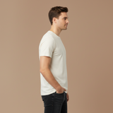 Man wearing a plain white t-shirt and dark jeans on a beige background
