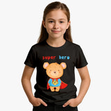 Child wearing a black t-shirt with a teddy bear superhero design on a plain background