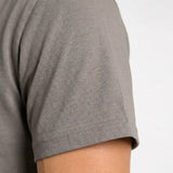 Close-up of a gray t-shirt sleeve on a plain background